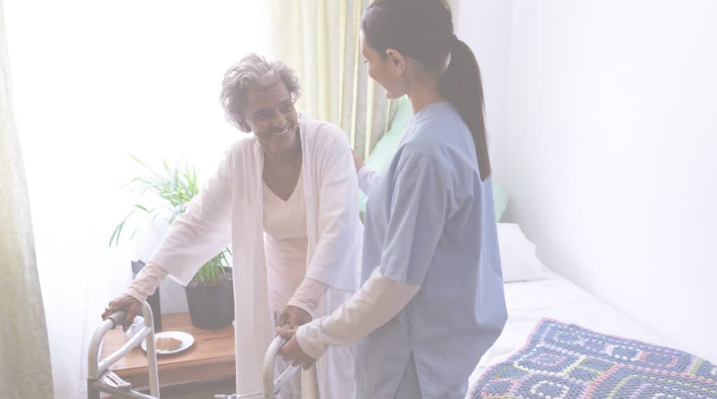 a nurse helping a senior patient using a walker out of bed