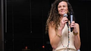 Photo of a woman with curly hair holding a microphone