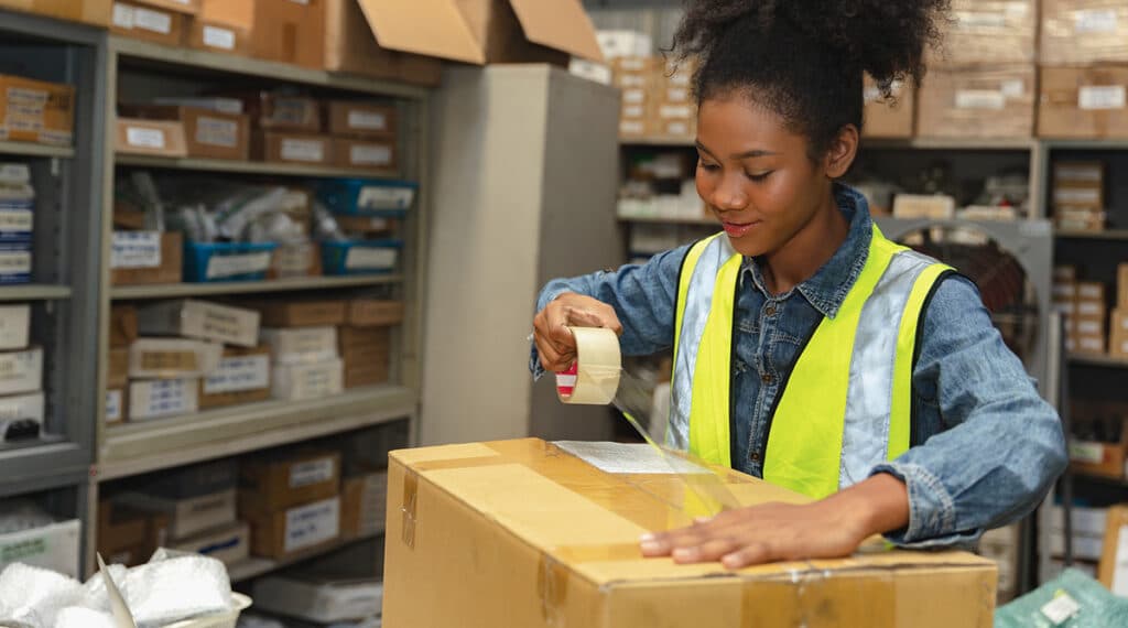 woman packing up box with supply tape